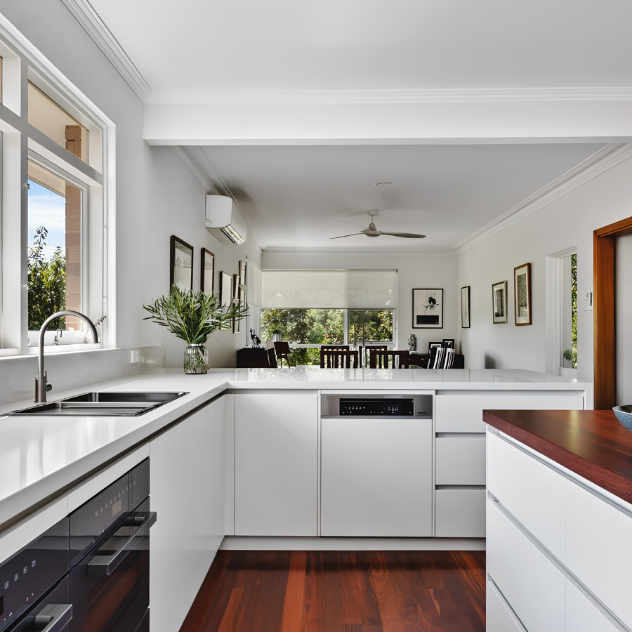 Bright kitchen with white cabinetry, timber benchtop and natural light
